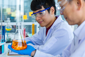 portrait closeup shot of asian mature male scientist teacher in white lab coat safety goggles and ru