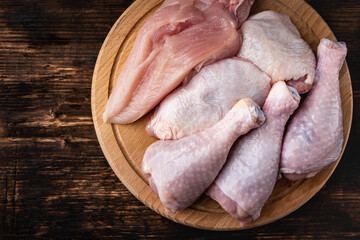 Wall Mural - Raw chicken meat: fillet, things and legs on dark wooden background.