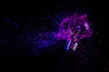 Wall Mural - explosion of an electric light bulb on black.