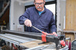 © Ladanifer - Senior contractor cutting a ceramic wood effect tile with a manual tile cutter.