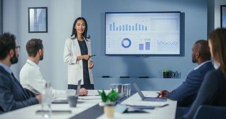 Leinwandbilder - Office Conference Room Meeting: Portrait of Confident Asian Female Top Manager Presents e-Commerce Investment Strategy for Group of Digital Entrepreneurs. Wall TV with Big Data Analysis, Infographics