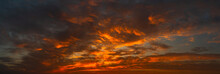 Panorama Sunset With Clouds, In Orange And Colorful Shades,World Environment Day Concept: Fiery Orange Sunset Sky With Dark Clouds.Abstract Dark Background.