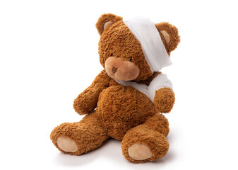 Wall Mural - medicine, healthcare and childhood concept - teddy bear toy with bandaged head and paw on white background