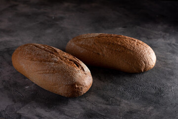 two loaves of bread on a dark background