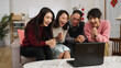 © PR Image Factory - family members waving hands to laptop screen and starting talking lively with hand gestures while making video call to friends on chinese lunar new year at home. word on door translation: spring