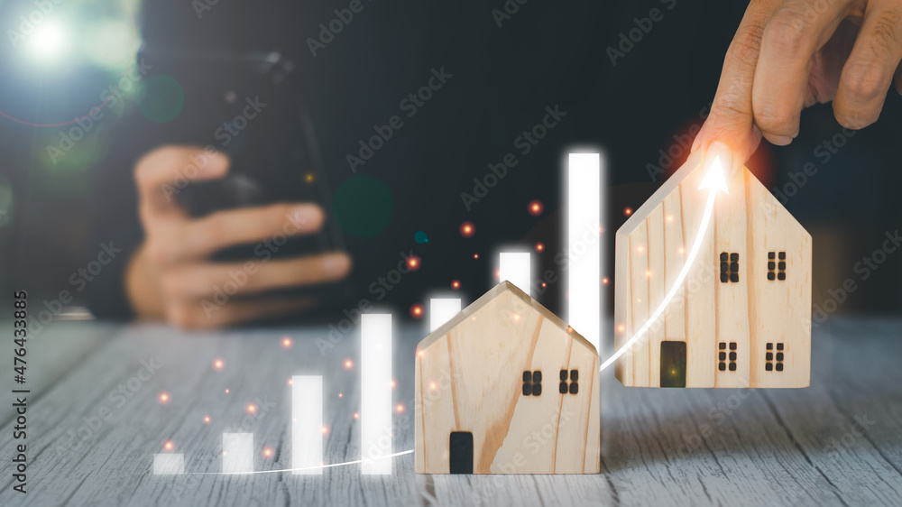 Real estate investment concept. Businessman holding wooden model houses ...
