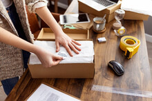 Young Woman Selling Products Online And Packaging Goods For Shipping. Women, Owener Of Small Business Packing Product In Boxes, Preparing It For Delivery.