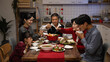 © PRPicturesProduction - happy asian family members picking food from hot pot with chopsticks while enjoying traditional reunion dinner at home on chinese new year's eve