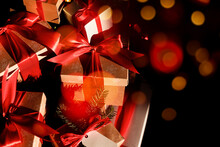 Festive Boxes With Gifts Tied With Red Ribbon On Dark Background, Orange Bokeh