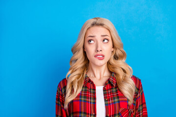 Canvas Print - Photo of nervous blond hairdo young lady bite lip look up wear red shirt isolated on blue color background