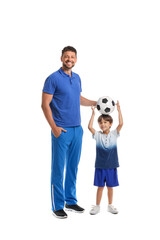 Poster - Little boy with soccer ball and trainer on white background