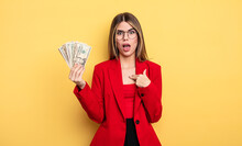 Businesswoman Looking Shocked And Surprised With Mouth Wide Open, Pointing To Self. Dollar Banknotes Concept