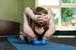 © somemeans - Girl lies on yoga mat and does back massage with roller for physiotherapy. Myofascial release with foam ball. Back view
