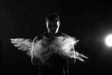 Portrait Of Sporty Young Man With Flying Talc Powder On Dark Background, Black And White Effect