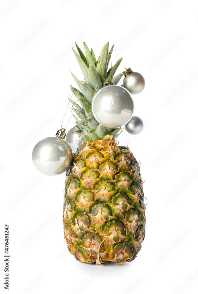 Fresh pineapple with Christmas balls on white background