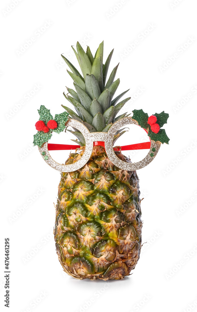 Funny pineapple in Christmas glasses on white background