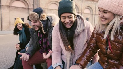 Wall Mural - Group of multiethnic friends laughing together outdoor - Happy young people talking and socializing together - Teenagers having fun on city street - Happy lifestyle and youth concept