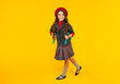 © be free - happy kid in school uniform with beret and backpack walk on yellow background, schoolgirl