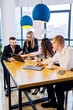 © Дмитрий Ткачук - Meeting of business people, discussing new business ideas, using diagrams, sitting together. Modern office background. Meeting of business partners at a business development conference