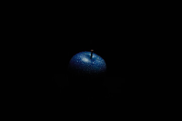 blue apple on black background