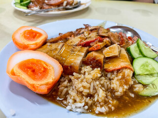 Wall Mural - Crispy belly pork on rice with barbecue red sauce and Egg topped. It is a delicious menu of Thai. Close up photo.