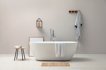 Canvas Print - Modern ceramic bathtub near light wall indoors