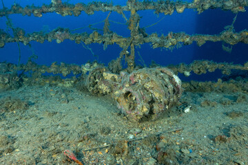 particolare di una saracinesca sul ponte di un relitto di petroliera naufragata vicino ad Renzano in Liguria, Italia circondato da anthias