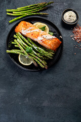Wall Mural - Baked salmon with asparagus on gray background.