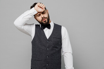 Wall Mural - Young barista male waiter butler man 20s wear white shirt vest elegant uniform work at cafe put hand on head forehead isolated on plain grey background studio portrait. Restaurant employee concept