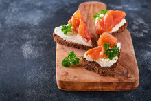Mini Sandwiches With Salmon, Curd Cheese, Parsley And Rye Bread In Form Of Hearts. Valentine's Day Homemade Creative Food. Love Breakfast Design. Selective Focus And Copy Space