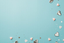 Top View Photo Of Valentine's Day Decorations Silver And Pink Hearts Confetti And Sequins On Isolated Pastel Blue Background With Empty Space