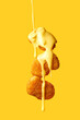 Levitating chicken nuggets topped with cheese sauce. Flying nuggets with flying sauce. Yellow background
