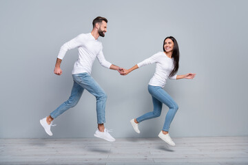 Poster - Full size profile photo of nice millennial brunet couple run wear white shirt jeans footwear isolated on grey background