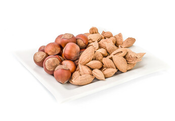 Wall Mural - Mixed nuts and dry fruits in plate isolated on Hazelnut and Walnut mix almond on white plate