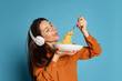 © master1305 - Cheerful young girl tasting delicious Italian pasta isolated on blue studio background. World pasta day