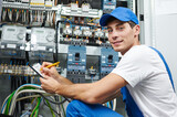 Fototapeta  - electrician worker inspecting equipment and electricity meter