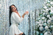 © Михаил Решетников - Sexy brunette holding a glass of champagne. Woman wishes a happy christmas