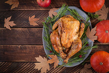 Roasted Turkey Garnished With Cranberries On A Rustic Style Table Decorated With Pumpkins, Apples And Autumn Leaf. Thanksgiving Day. Flat Lay. Top View