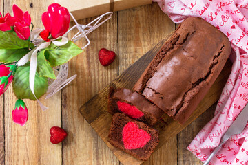 St. Valentine's Day, Birthday or Mother's Day dessert, homemade festive food. Homemade sweet chocolate brownie cake with red heart on a wooden rustic tabletop. Top view flat lay.