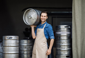 Wall Mural - Attractive confident strong man working at plant. Owner of brewery, employee at storage