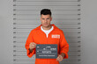 © New Africa - Prisoner with mugshot letter board at police department