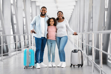 Wall Mural - Black family traveling, posing together in airport