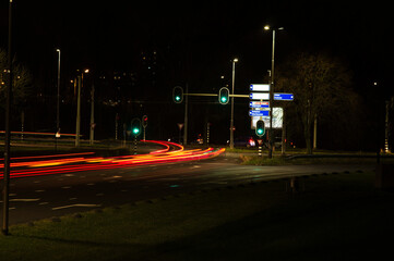 Wall Mural - Intersection at night with traffic lights and traffic blurred by motion in Arnhem in the Netherlands