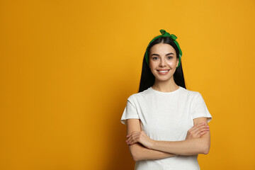 Wall Mural - Young woman wearing stylish bandana on orange background, space for text