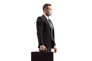 Poster - Businessman holding a briefcase and wearing a protective face mask