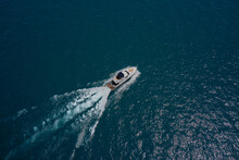 Large White Yacht On The Water In Motion Top View. Travel On High-speed Boats On The Water. Luxury Motor Boat On Dark Blue Water Aerial View. Yacht Movement On Dark Water.
