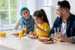 © Prostock-studio - Cheerful middle eastern family of three having healthy breakfast together in kitchen