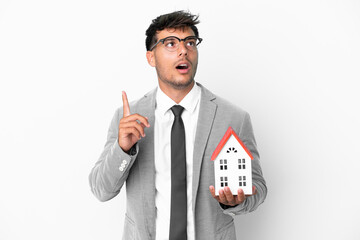 Poster - Business man holding a house isolated on blue background thinking an idea pointing the finger up