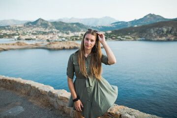 Lifestyle portrait of woman with sunglasses. Traveler next to the sea. Beautiful young, caucasian woman. 