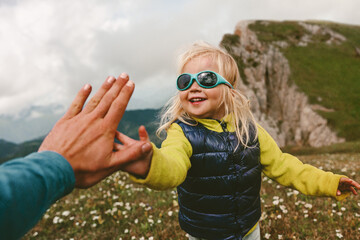 Family fun child high five hands with father active vacations hiking in mountains together healthy lifestyle camping outdoor success happiness emotions